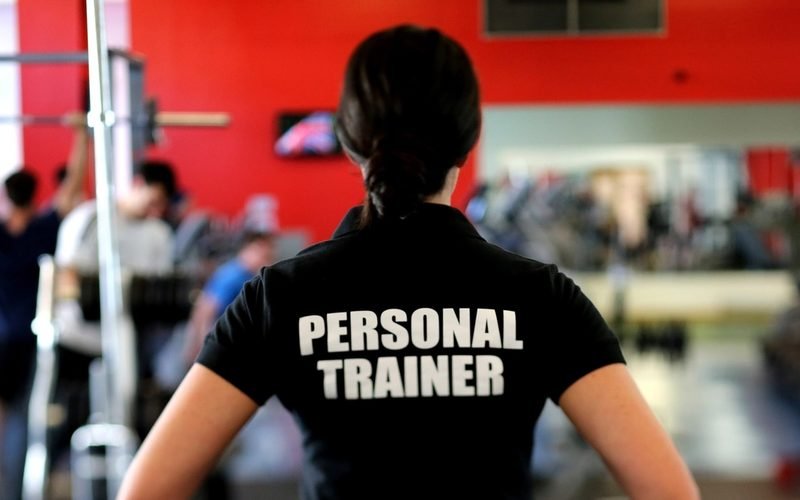 Entrenador personal de espaldas, con polo de personal trainer